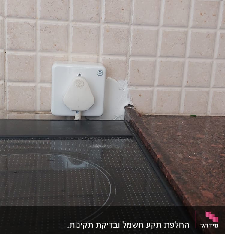 שקע חשמלי עם תקע על קיר מטבח